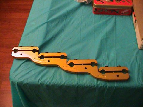 1979 Ford Bronco - A gold-colored engine part with multiple clamps is laid out on a teal cloth surface.
