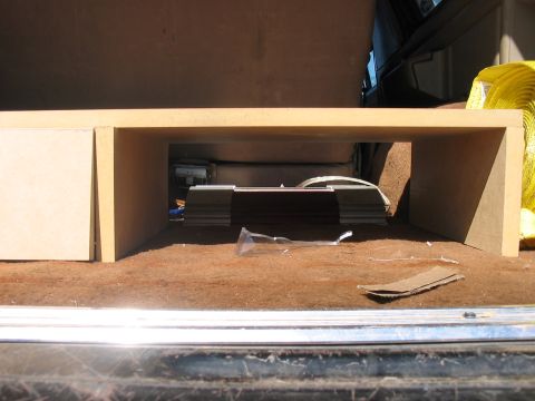 1988 Ford Bronco - A custom storage unit is installed in the rear cargo area of a vehicle, with items stored underneath.