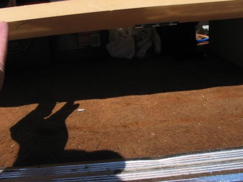 1988 Ford Bronco - A view inside a vehicle's storage area, showing carpeted floor and a wooden shelf overhead.