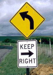 1998 Ford Taurus - Traffic signs indicate a left turn ahead with a requirement to keep right.