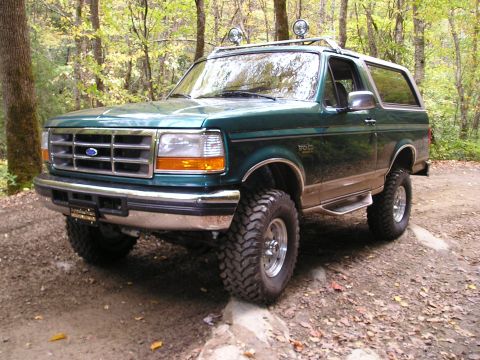 1996 Ford Bronco - This 1996 Ford Bronco is shown on a dirt path with trees in the background.