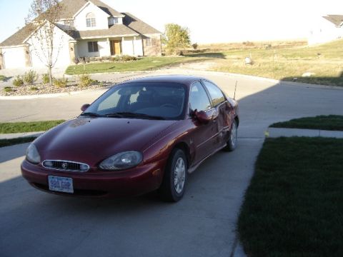 1998 Mercury Sable - Maroon 1998 Mercury Sable parked in front of a house. The car has visible damage on the passenger side.