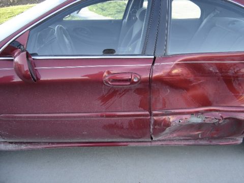 1998 Mercury Sable - This red sedan has extensive damage to its rear passenger side door and quarter panel.