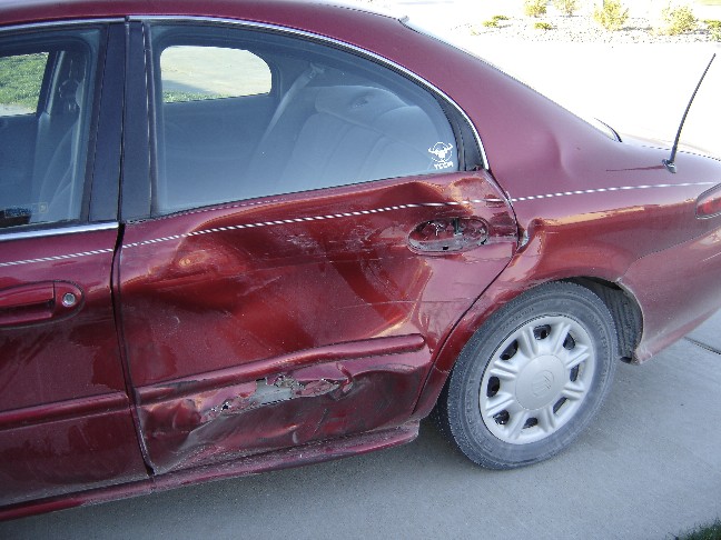 Red 1998 Mercury Sable sedan with severe rear passenger side damage