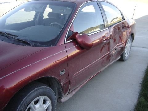 1998 Mercury Sable - This maroon sedan shows extensive damage to its right rear side, indicating a significant impact.