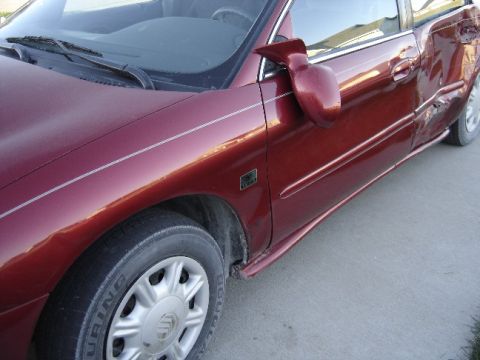 1998 Mercury Sable - This 1998 Mercury Sable shows extensive damage on its right rear side, indicating a severe impact.