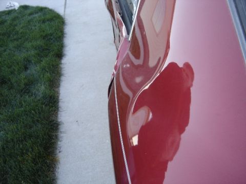 1998 Mercury Sable - The side of a red car shows significant damage to the door panel.