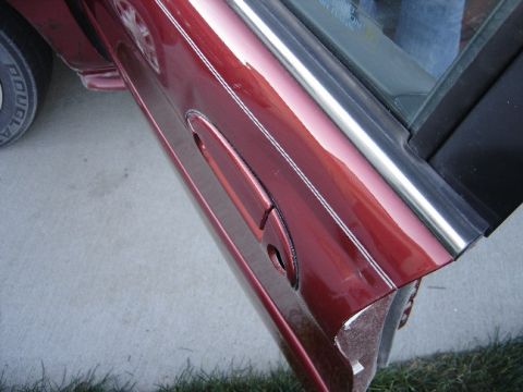 1998 Mercury Sable - Close-up of the side door and tire of a 1998 Mercury Sable.