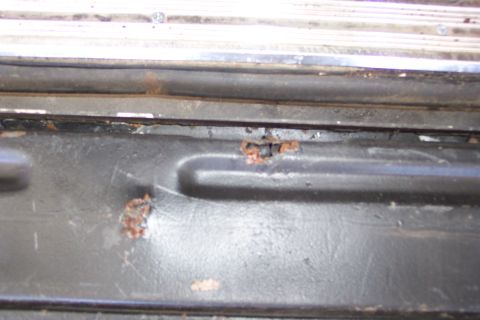 1986 Ford Bronco - Rust is visible on the lower edge of a vehicle's tailgate, indicating potential damage.