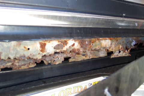 1986 Ford Bronco - Severe rust damage on a vehicle's rocker panel, with a partial Florida license plate visible.