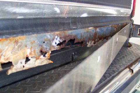 1986 Ford Bronco - This photo shows extensive rust damage on a vehicle's lower body panel, indicating a need for repair.