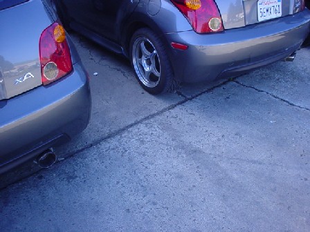 1993 Ford Taurus - Two gray cars are parked side-by-side, showing their rear ends and taillights.