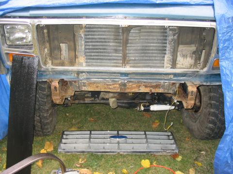 1986 Ford Bronco - Front end of a Ford Bronco with the grille removed, exposing the radiator and bumper assembly.