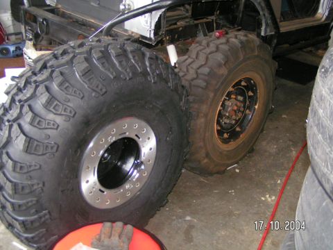 1978 Ford Bronco - This image focuses on the massive off-road tires and the underlying chassis of a vehicle, suggesting a custom build or modification.