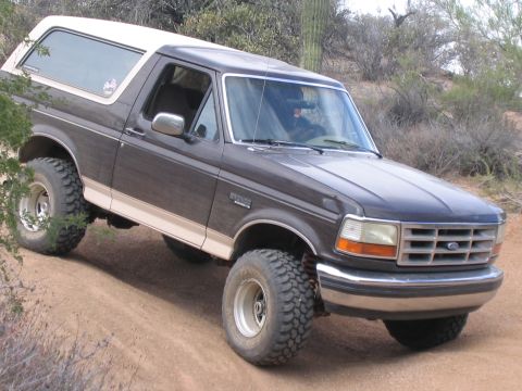 1995 Ford Bronco - This 1995 Ford Bronco is shown navigating an off-road trail in a desert environment.