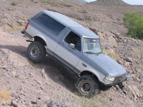 1995 Ford Bronco - This two-tone silver and gray Ford Bronco navigates a steep, rocky incline.