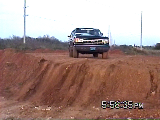 Ford F-Series truck driving over a dirt mound. Time stamp 5:58:35 PM