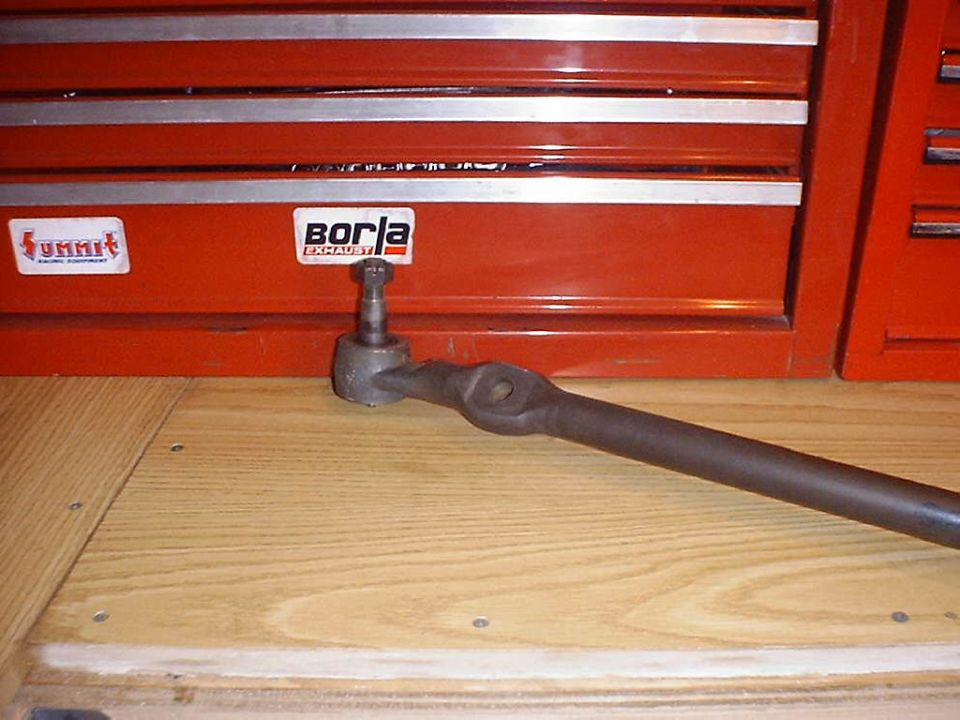 Tie rod end with Borla and Summit Racing Equipment stickers on a red toolbox