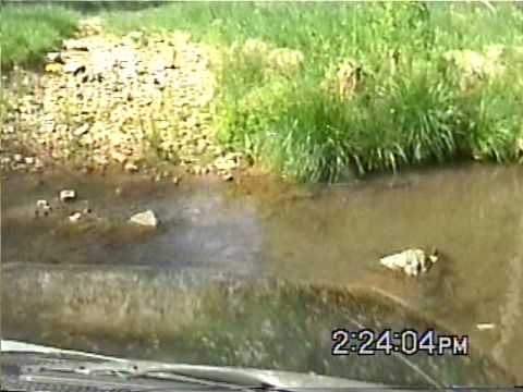 1988 Ford Bronco - This 1988 Ford Bronco navigates a shallow stream, kicking up water as it goes.