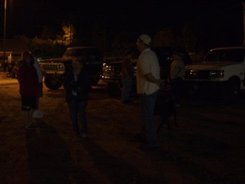 1996 Ford Bronco - A group of people stand around a dark Ford Bronco at night.
