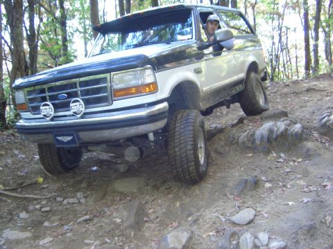 1996 Ford Bronco - A two-tone Ford Bronco navigates a challenging off-road course.