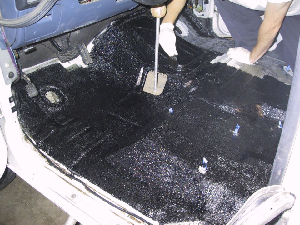Applying black coating to the floor of a vehicle, covering the transmission tunnel and footwells