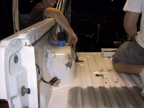 1993 Ford Bronco - Workers are seen inside the bed of a vehicle, possibly preparing it for a new coating.