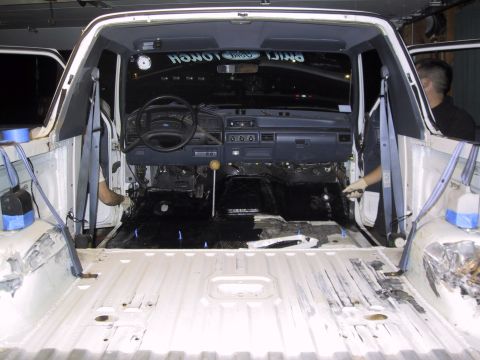 1993 Ford Bronco - The interior of a 1993 Ford Bronco is shown with its components removed, revealing the bare metal floor and dashboard.