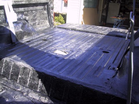 1993 Ford Bronco - The interior of a vehicle bed is shown with a black Herculiner coating applied to protect the surface.