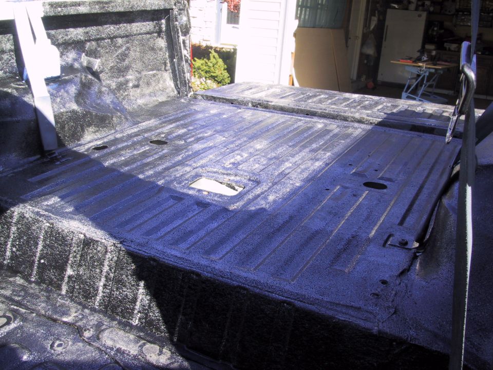 Vehicle bed interior with black Herculiner coating and ribbed floor