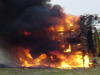 1992 Ford Bronco - A vehicle is burning intensely, with thick black smoke billowing upwards.