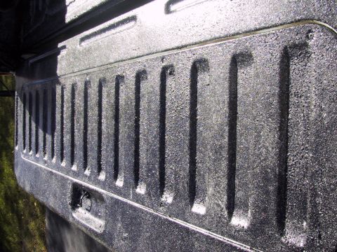 1993 Ford Bronco - The textured surface of a truck bed liner is shown in detail, a row of raised, parallel ridges.