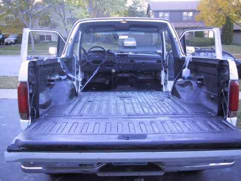 1993 Ford Bronco - Interior view of a white Ford truck, showing the bed and dashboard with doors ajar.
