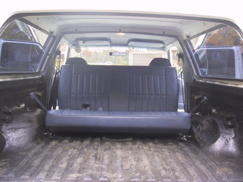 1993 Ford Bronco - The interior of a vehicle shows a rear bench seat and the cargo area, with no visible year-identifying features.