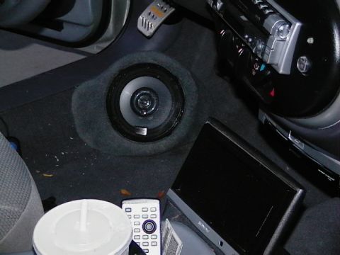 1999 Ford Taurus - A close-up view of a car's interior reveals a speaker, remote, and a display screen.