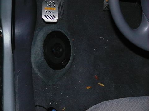 1999 Ford Taurus - The driver's side footwell shows aftermarket pedals and a speaker installed in the carpeted floor.