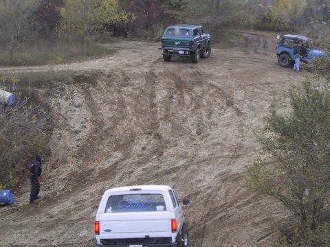 1993 Ford Bronco - A white 1993 Ford Bronco navigates a dirt path alongside other off-road vehicles during an outing.