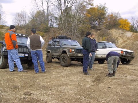 1993 Ford Bronco - A group of men and their off-road vehicles gather on a dirt path during an outing.