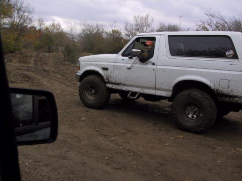 1993 Ford Bronco - A white 1993 Ford Bronco navigates a muddy off-road path during a club trip.