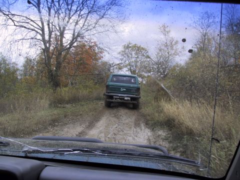 1993 Ford Bronco - Two vehicles navigate a muddy off-road trail during an autumn outing.