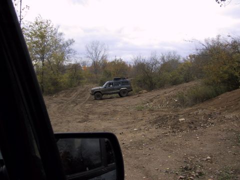 1993 Ford Bronco - A Jeep Cherokee XJ navigates a rough, unpaved track during an off-road excursion.