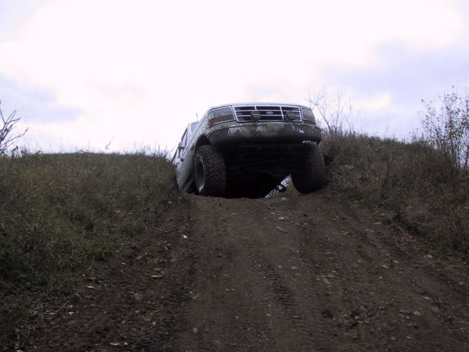Ford F-Series truck going up a dirt hill, front wheels off the ground