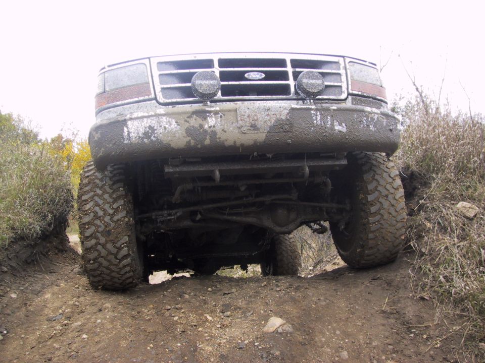 1993 Ford Bronco front end covered in mud, driving off-road