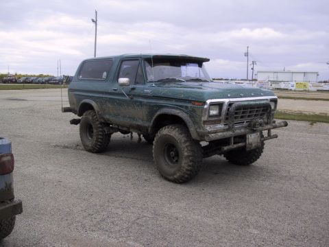 1993 Ford Bronco - This lifted green Ford Bronco is covered in mud, suggesting off-road use.