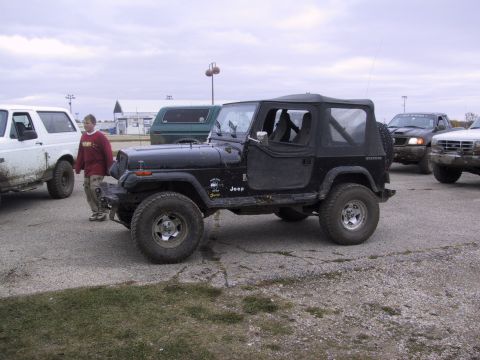1993 Ford Bronco - A group of off-road vehicles gathered on a cloudy day.