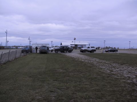 1993 Ford Bronco - Several SUVs and a car are gathered in an outdoor lot under an overcast sky.