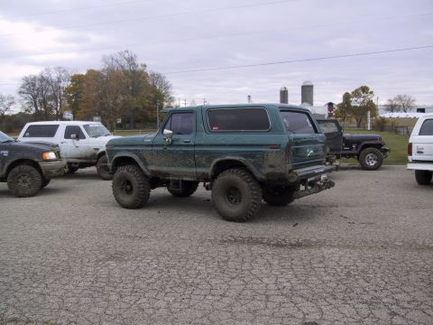 1993 Ford Bronco - Several off-road vehicles are gathered together on a cloudy day.