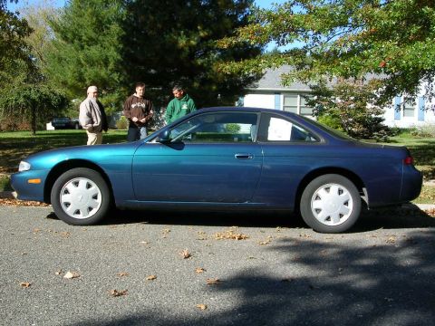 1995 Nissan 240SX - Side profile of a blue 1995 Nissan 240SX coupe on a residential street.
