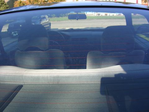 1995 Nissan 240SX - View of the car's interior from the outside, with another vehicle visible in the background.