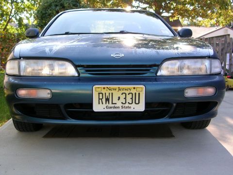 1995 Nissan 240SX - Front view of a dark teal 1995 Nissan 240SX parked on a concrete driveway.
